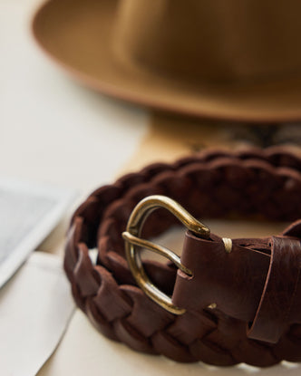 editorial image of The Braided Belt in Dark Brown rolled up on a piece of paper