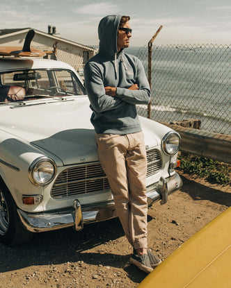 fit model leaning against a vintage car in The Apres Pant in Khaki Double Cloth