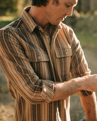 fit model rolling up the sleeves on The Ledge Shirt in Sunset Stripe