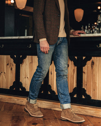 fit model leaning against a chair wearing The Rambler Chukka in Mushroom Suede