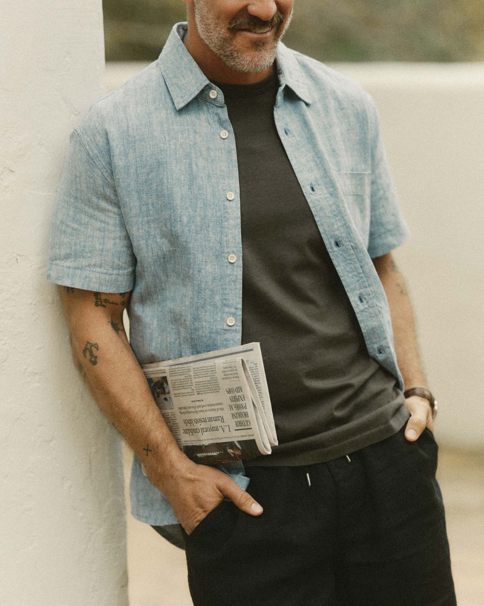 fit model leaning against the wall wearing The Short Sleeve California in Sky Hemp, Wovens by Taylor Stitch