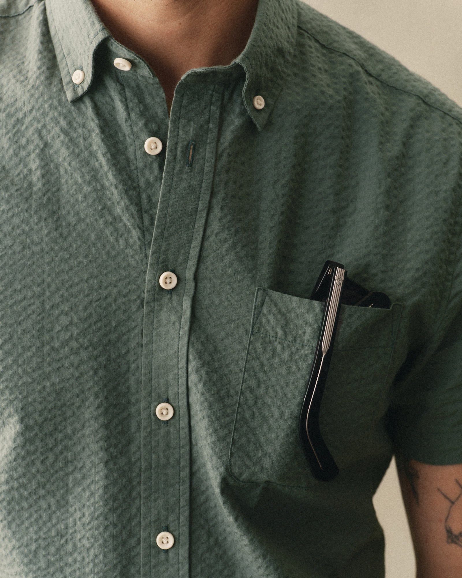 fit model showing off the pocket on The Short Sleeve Jack in Deep Sea Seersucker, Wovens by Taylor Stitch