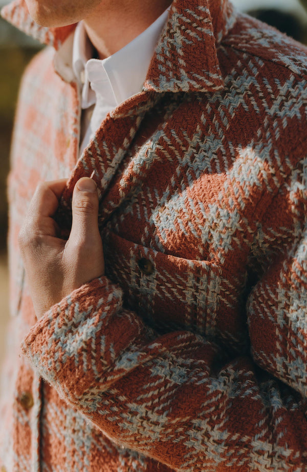 fit model adjusting the buttons on The Cutter Overshirt in Salmon Plaid