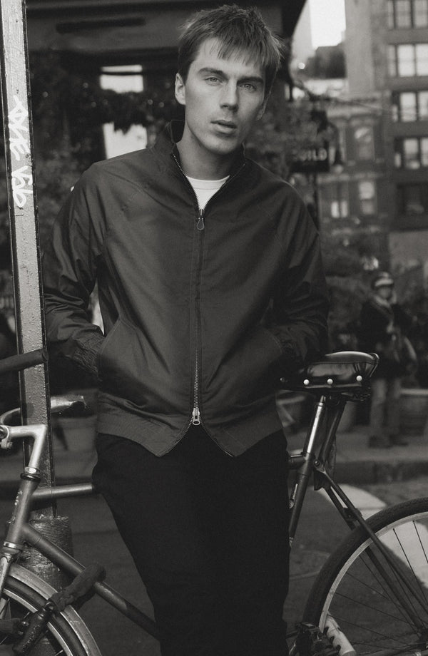 fit model sitting on a bike wearing The Dean Jacket in Dark Spruce Twill