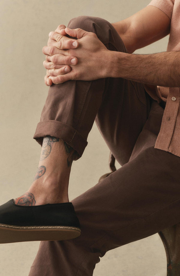 A pair of Foundation Pants folded on a black background, showing the back pocket.