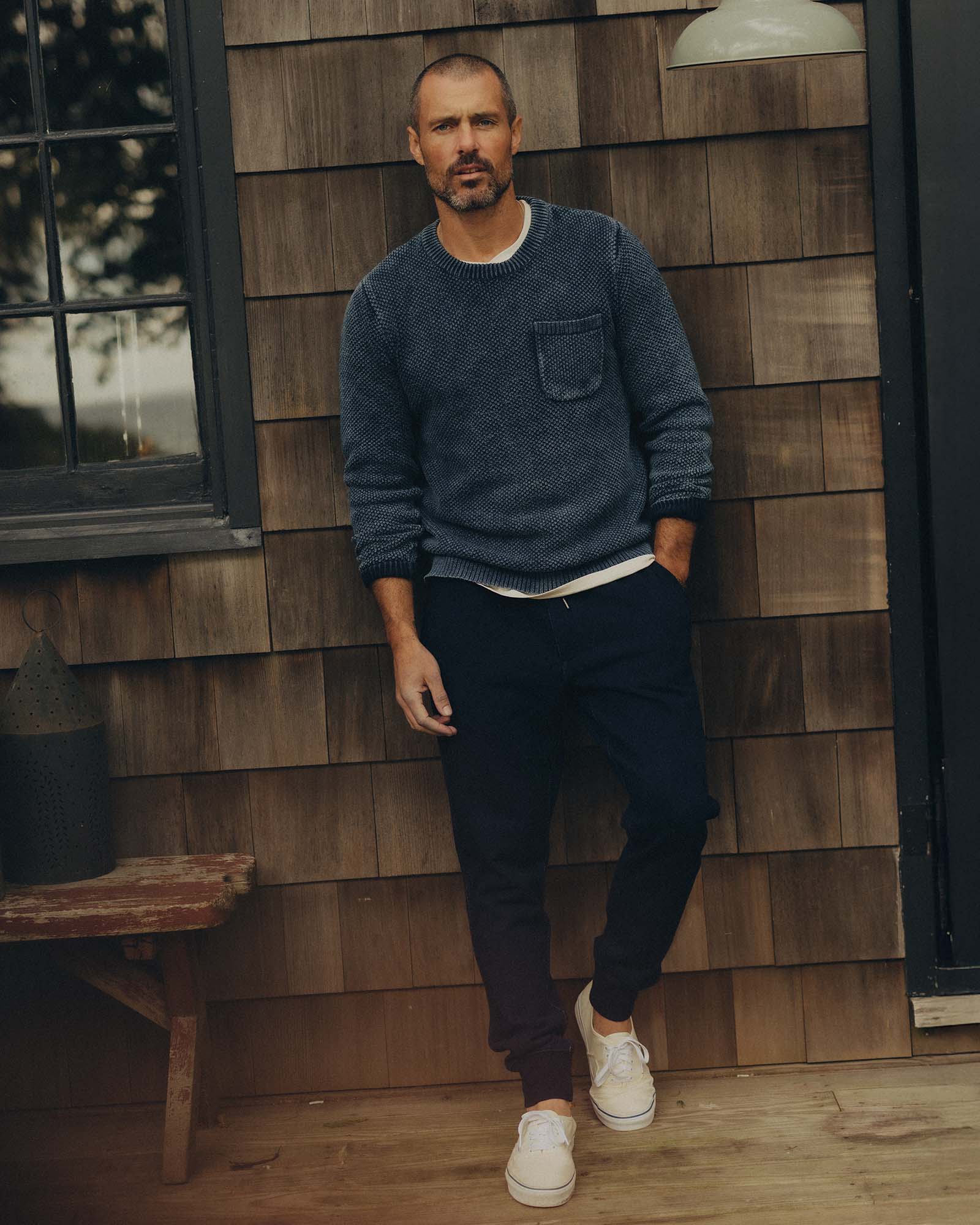 fit model leaning against the wall wearing The Crawford Crew Sweater in Washed Indigo, Knits by Taylor Stitch