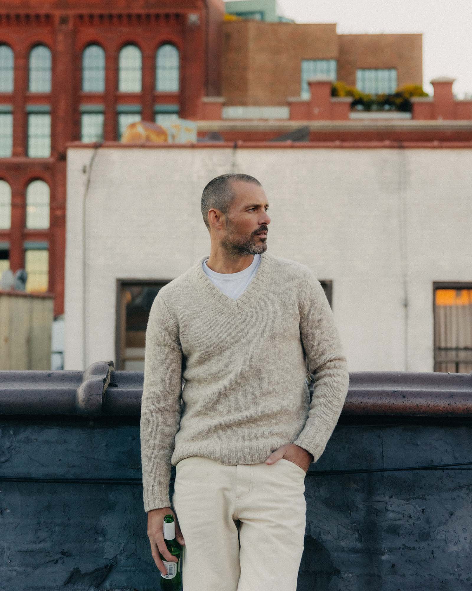 fit model leaning against the wall wearing The Match V-Neck Sweater in Sable Merino Slub, Knits by Taylor Stitch