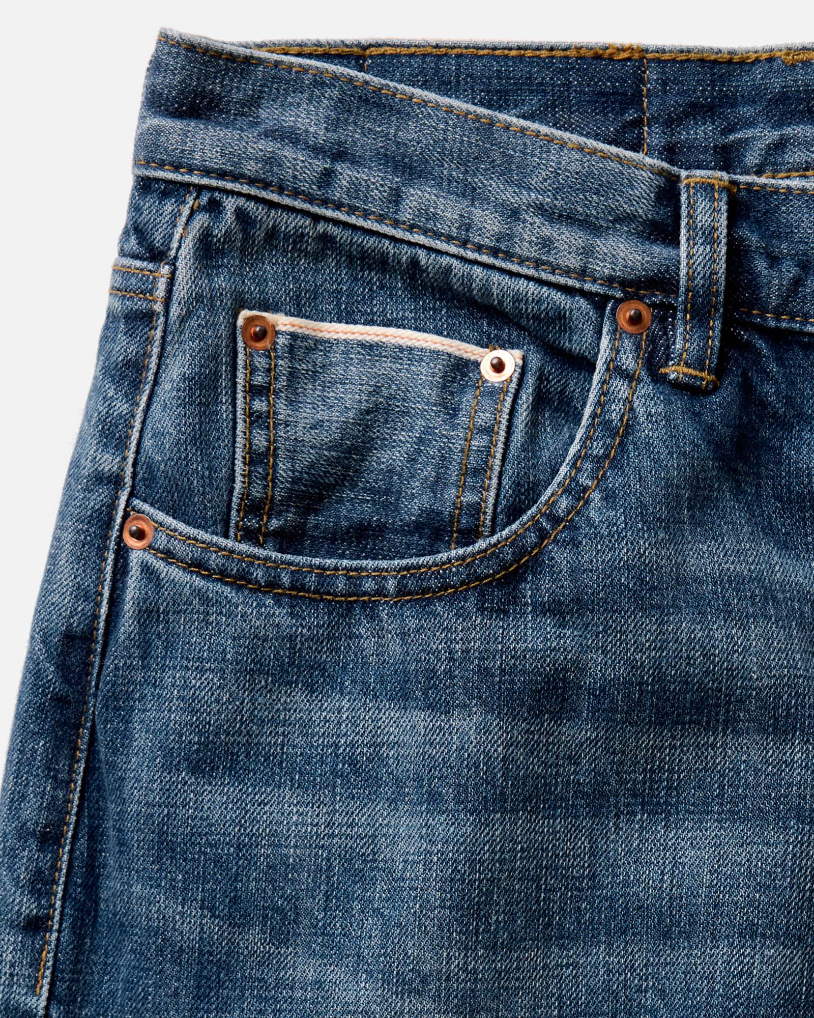 fit model sitting wearing The Democratic Jean in Mid Wash Organic Selvedge, Bottoms by Taylor Stitch
