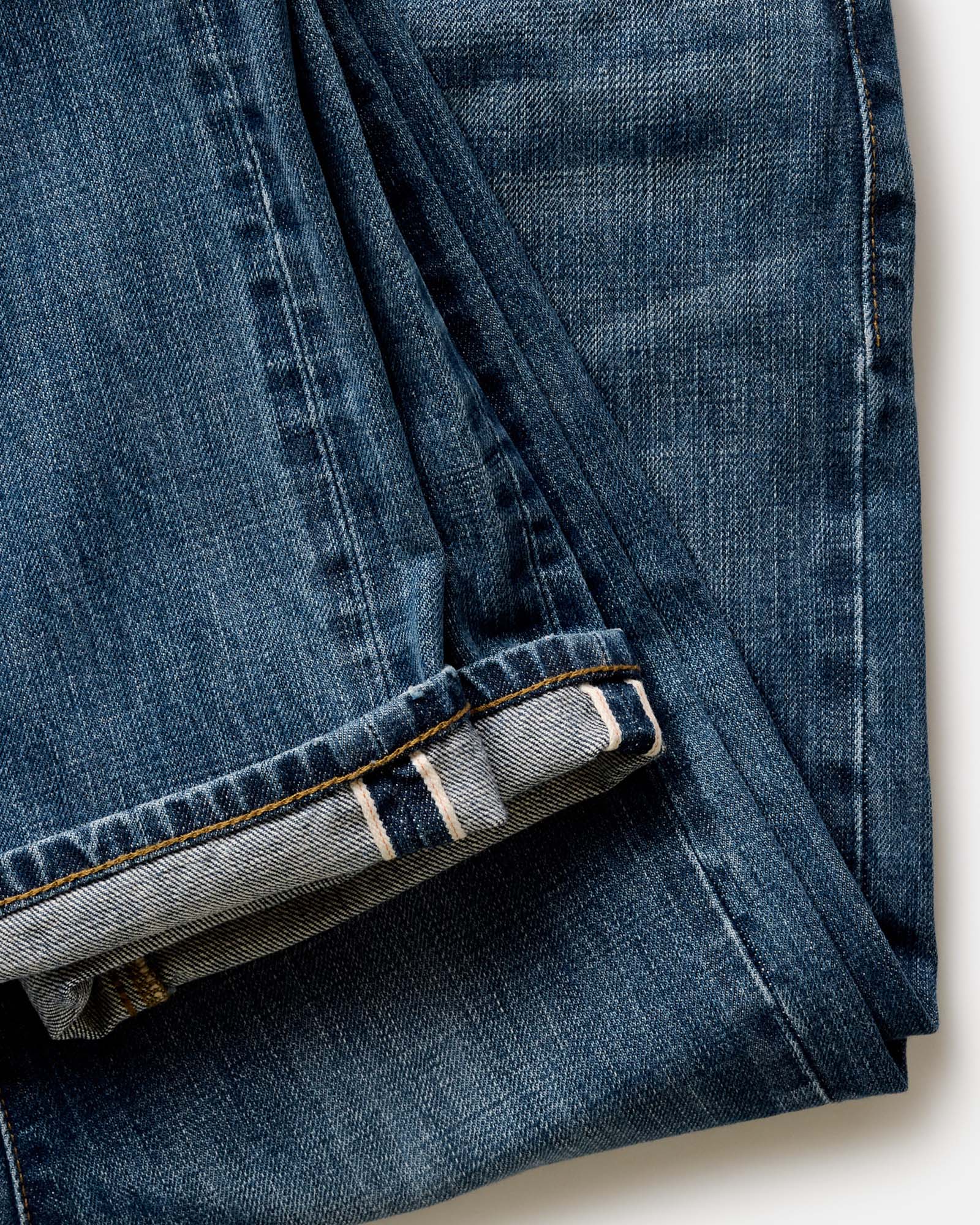 fit model posing in The Democratic Jean in Mid Wash Organic Selvedge, Bottoms by Taylor Stitch