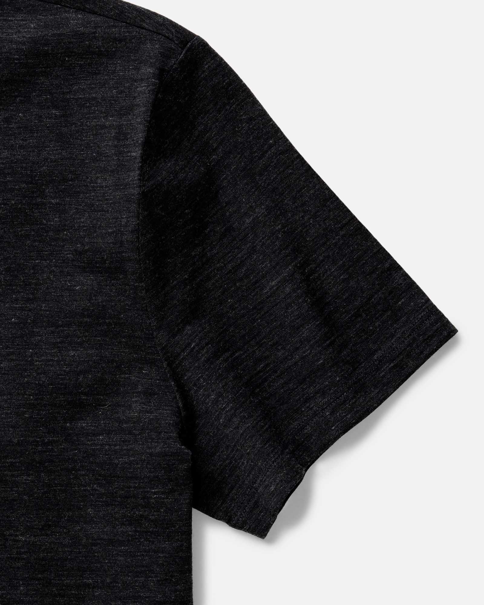 fit model sitting wearing The Merino Tee in Heather Black, Knits by Taylor Stitch