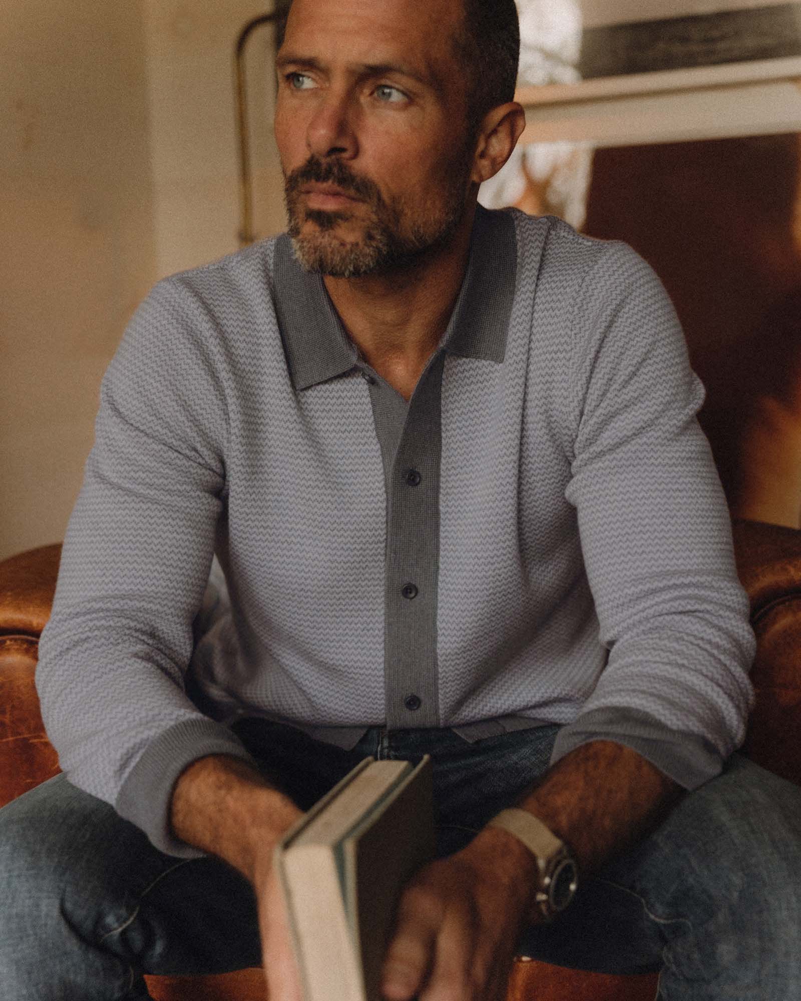 fit model sitting wearing The Nichols Polo in Heather Grey Birdseye Merino, Knits by Taylor Stitch