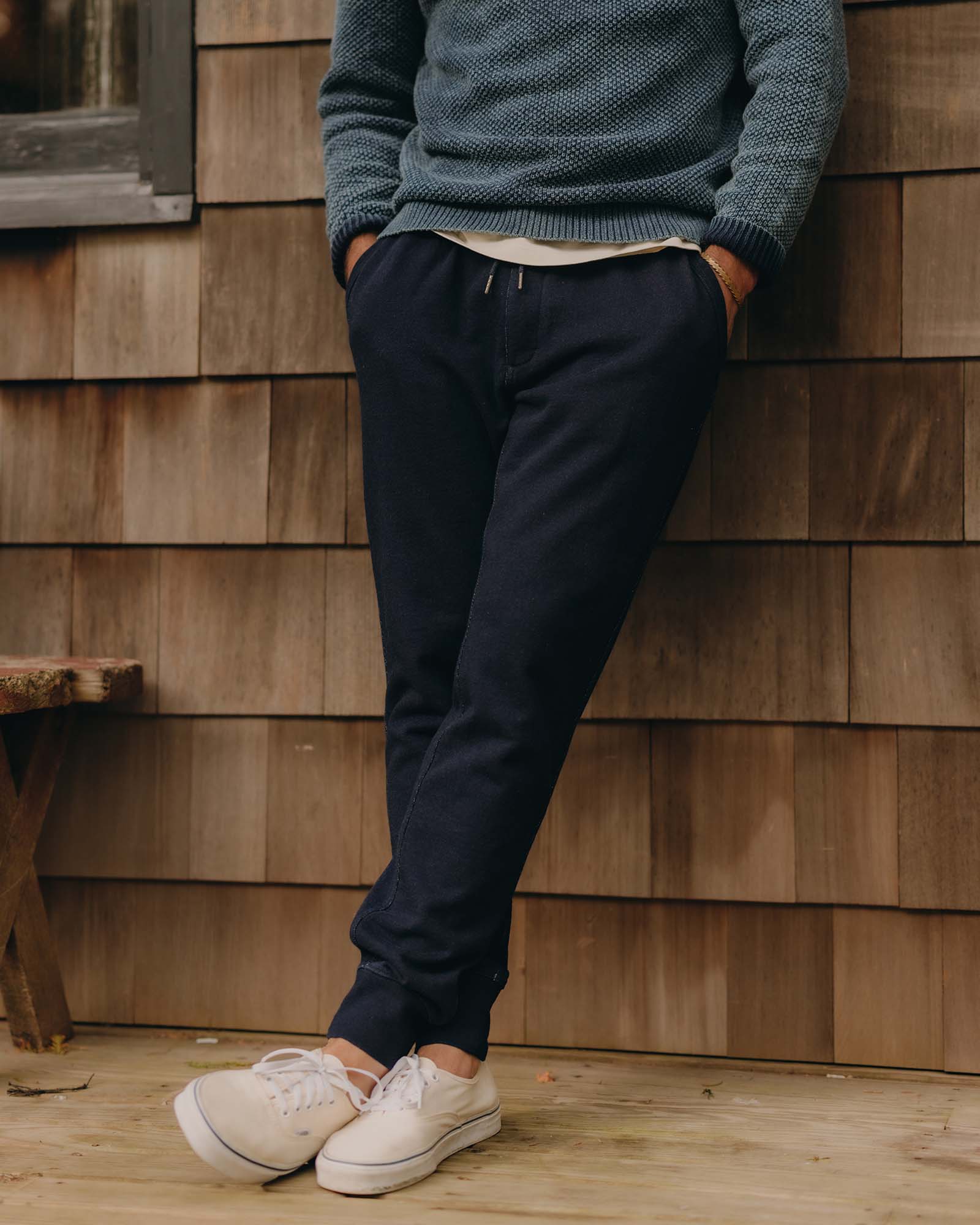 fit model leaning against the wall wearing The Sunset Pant in Rinsed Indigo Terry, Bottoms by Taylor Stitch