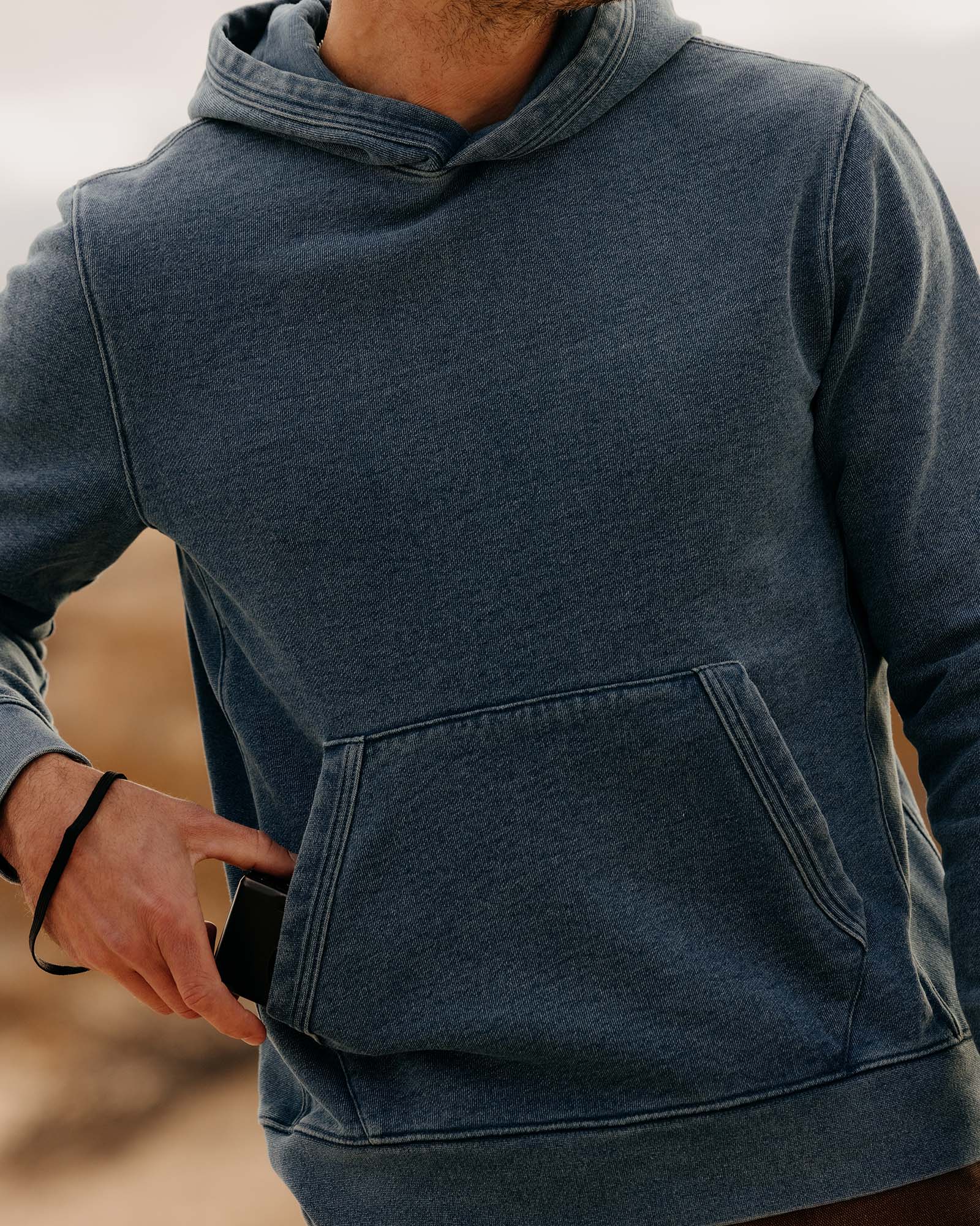 fit model posing wearing The Apres Hoodie in Washed Indigo Terry, Knits by Taylor Stitch