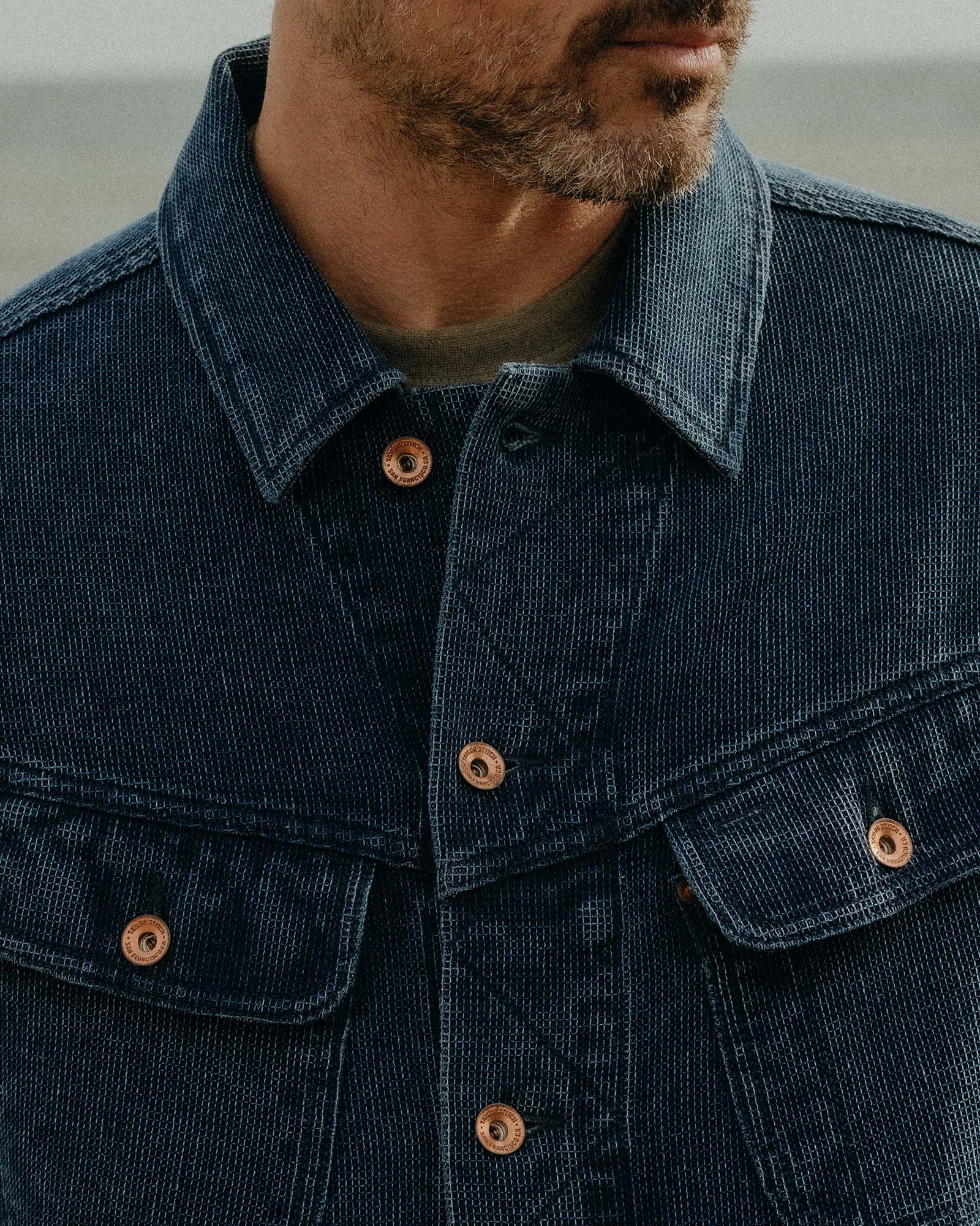 close up of the front pockets and antique copper buttons on The Long Haul Jacket in Rinsed Indigo Waffle, Outerwear by Taylor Stitch