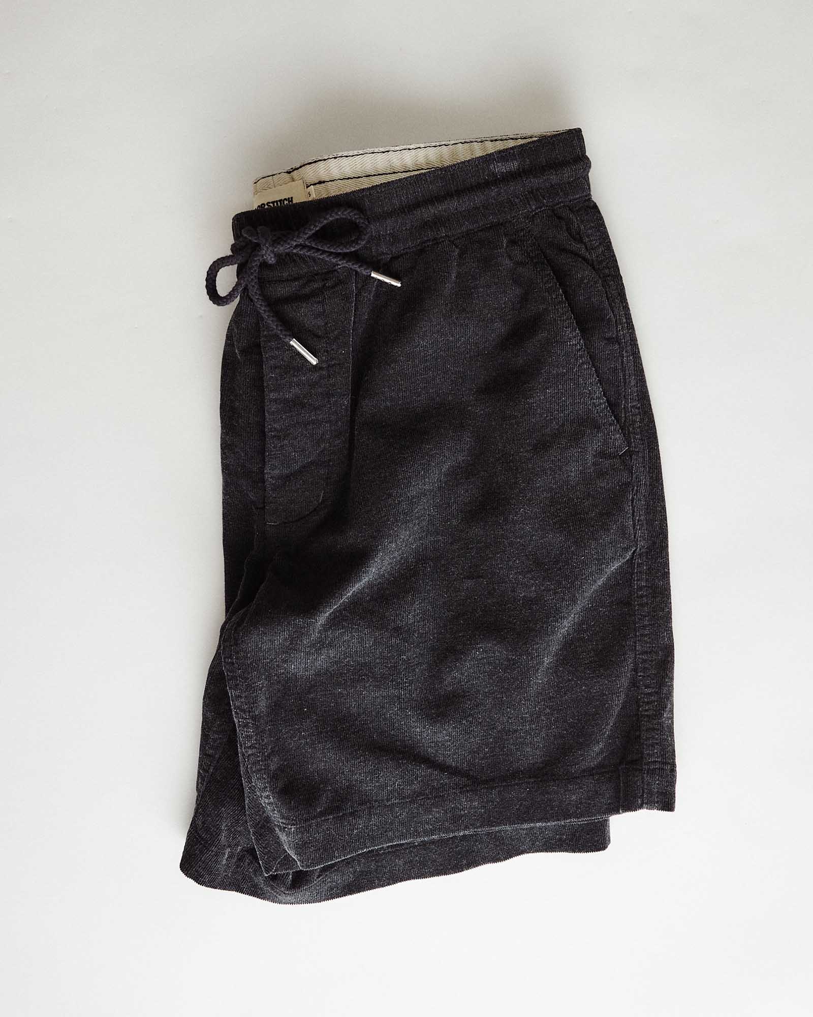 editorial flatlay of The Apres Short in Heather Coal Pincord, Bottoms by Taylor Stitch
