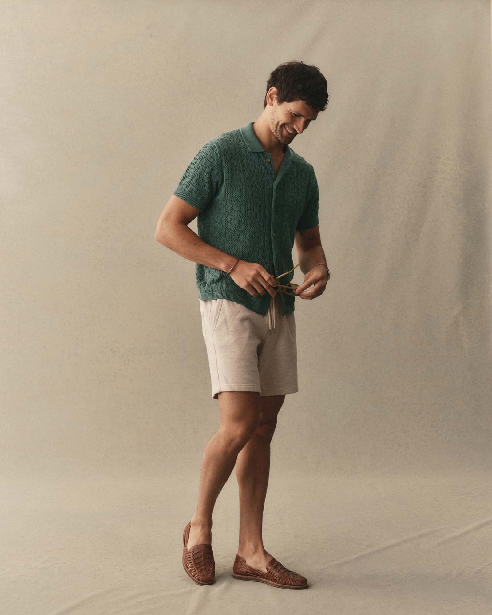 fit model walking wearing The Monterey Sweater Polo in Deep Sea Geo Crochet, Knits by Taylor Stitch