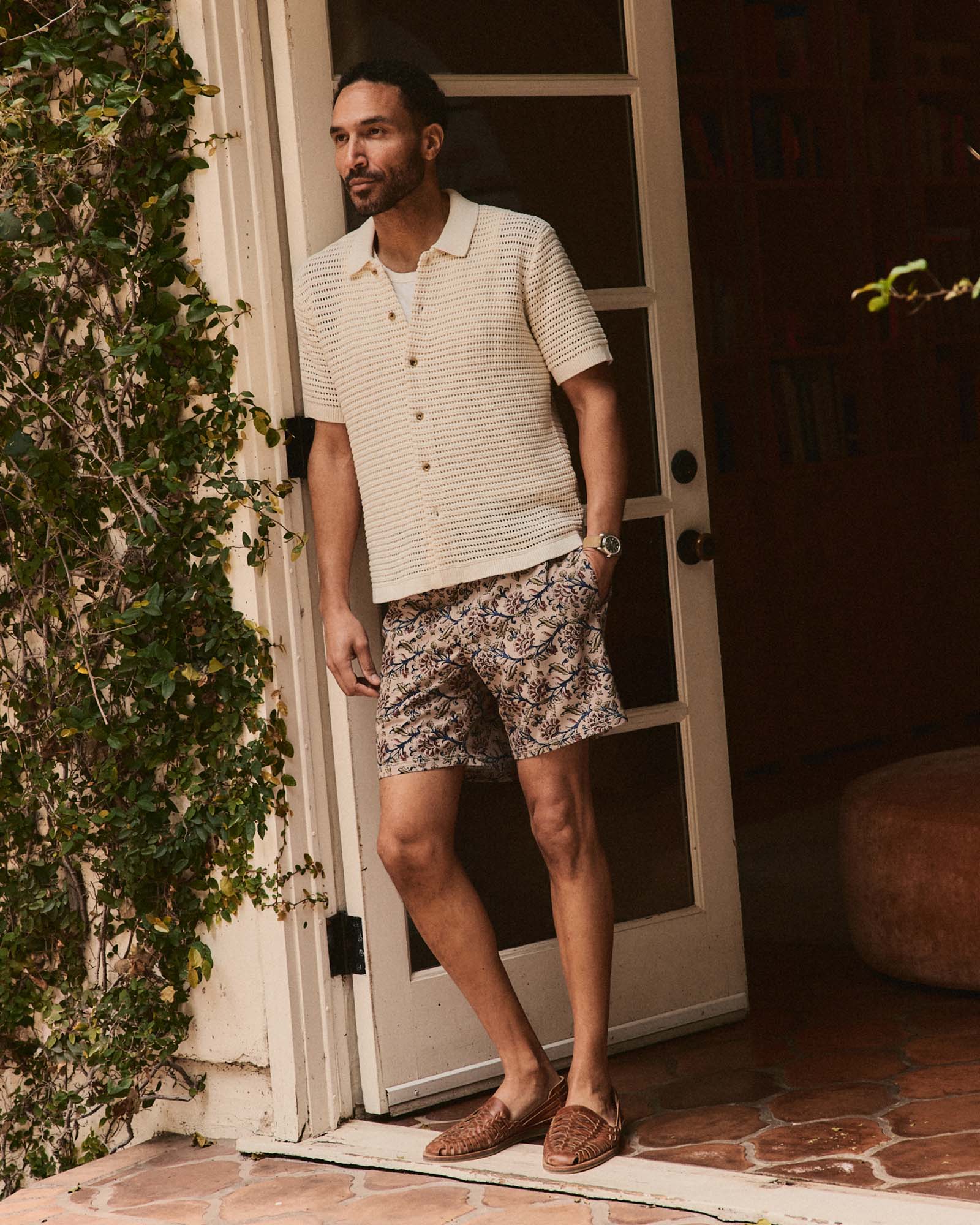 fit model leaning against the wall wearing The Monterey Sweater Polo in Vintage White Crochet, Knits by Taylor Stitch