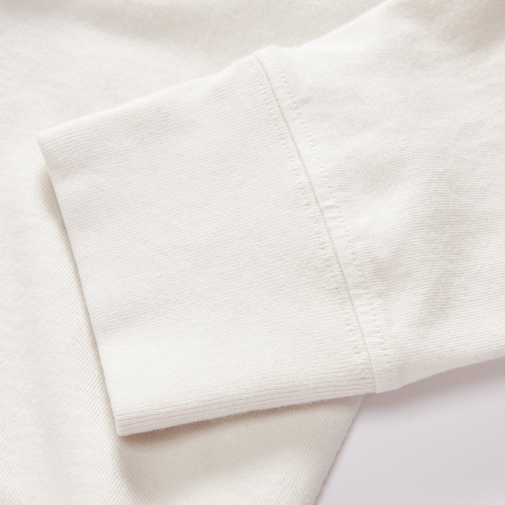 material shot of the sleeves on The Organic Cotton Henley in Vintage White, Knits by Taylor Stitch