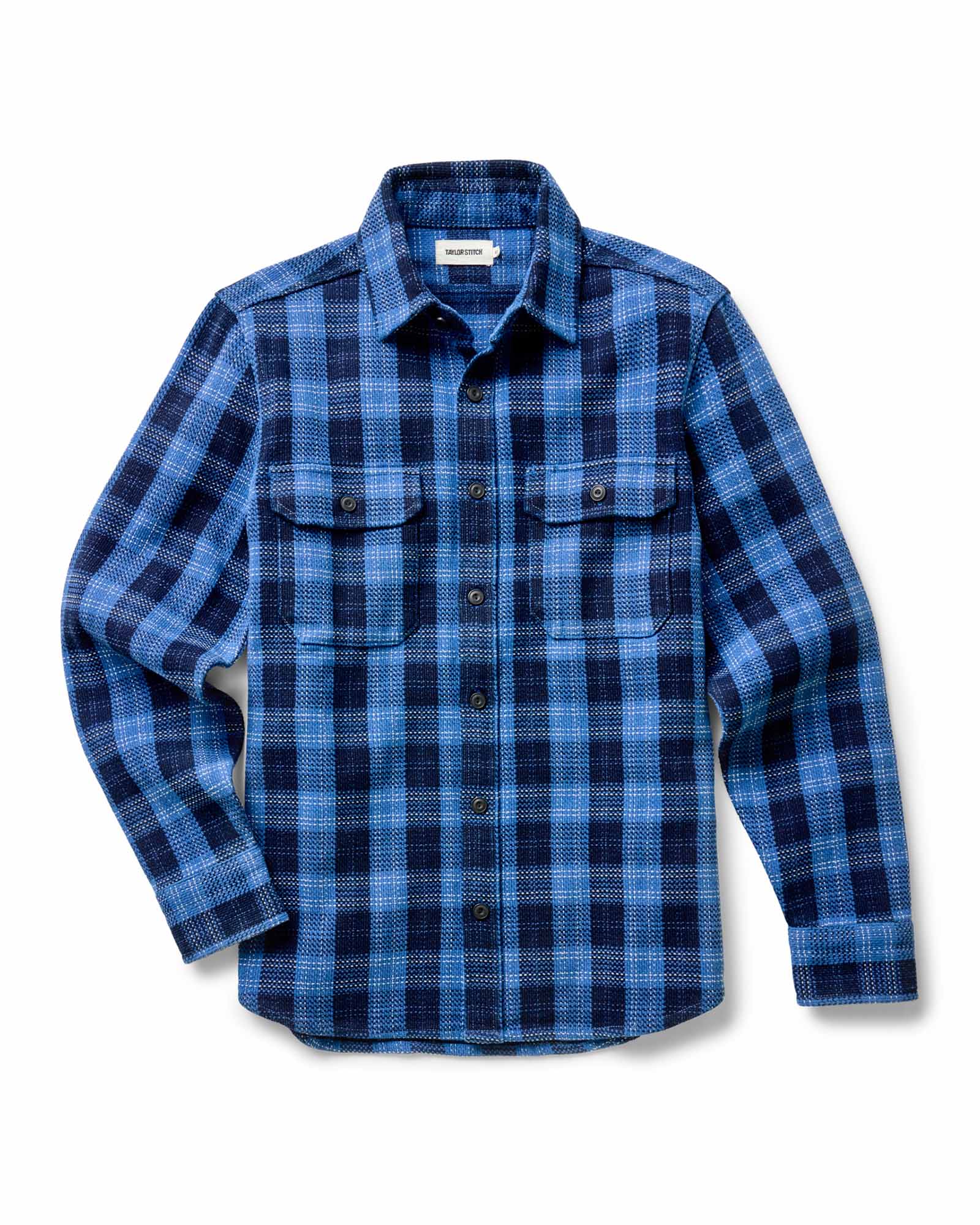 fit model holding a log wearing The Division Shirt in Rinsed Indigo Plaid, Wovens by Taylor Stitch