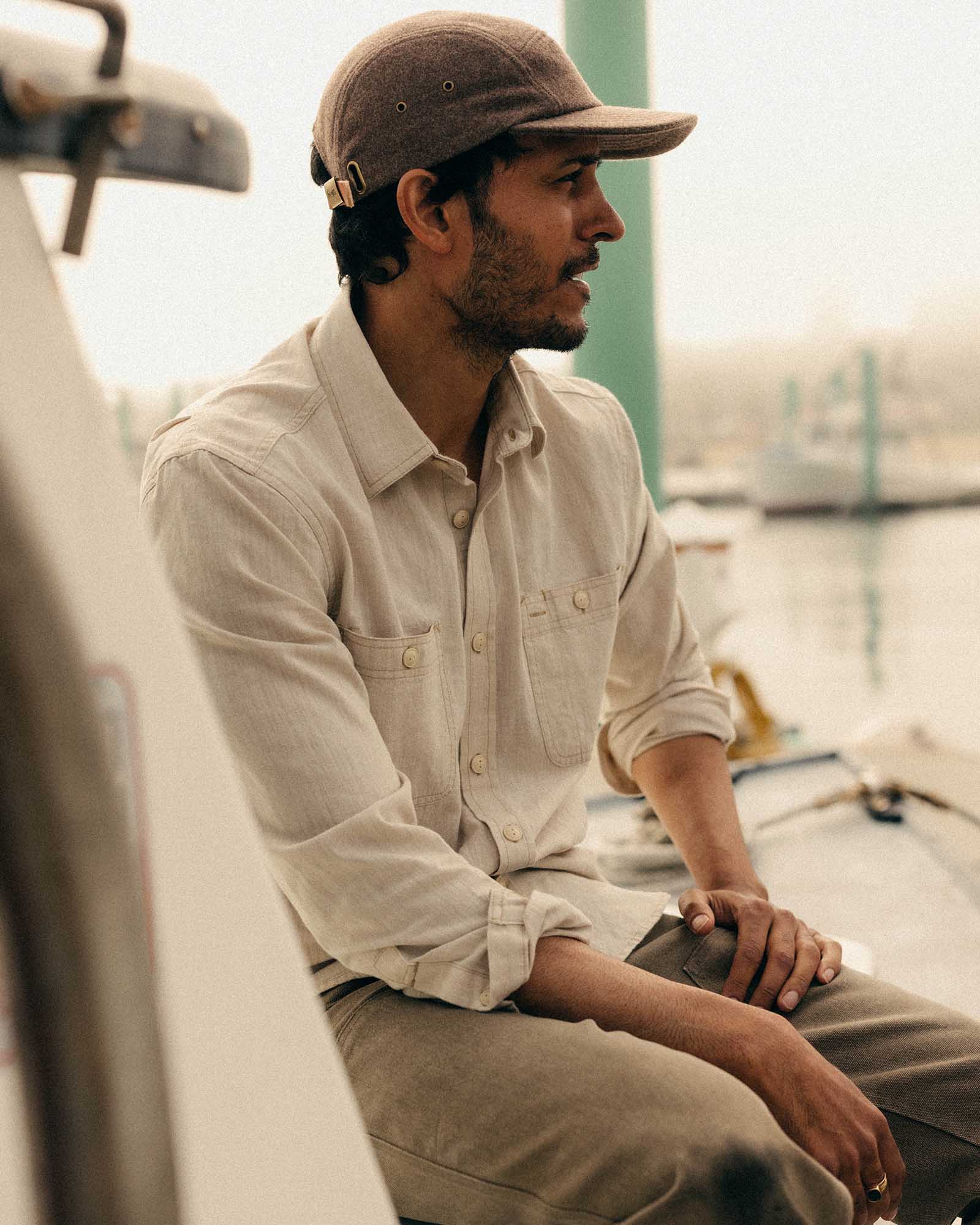 fit model sitting wearing The Foundry Shirt in Natural Chambray, Wovens by Taylor Stitch