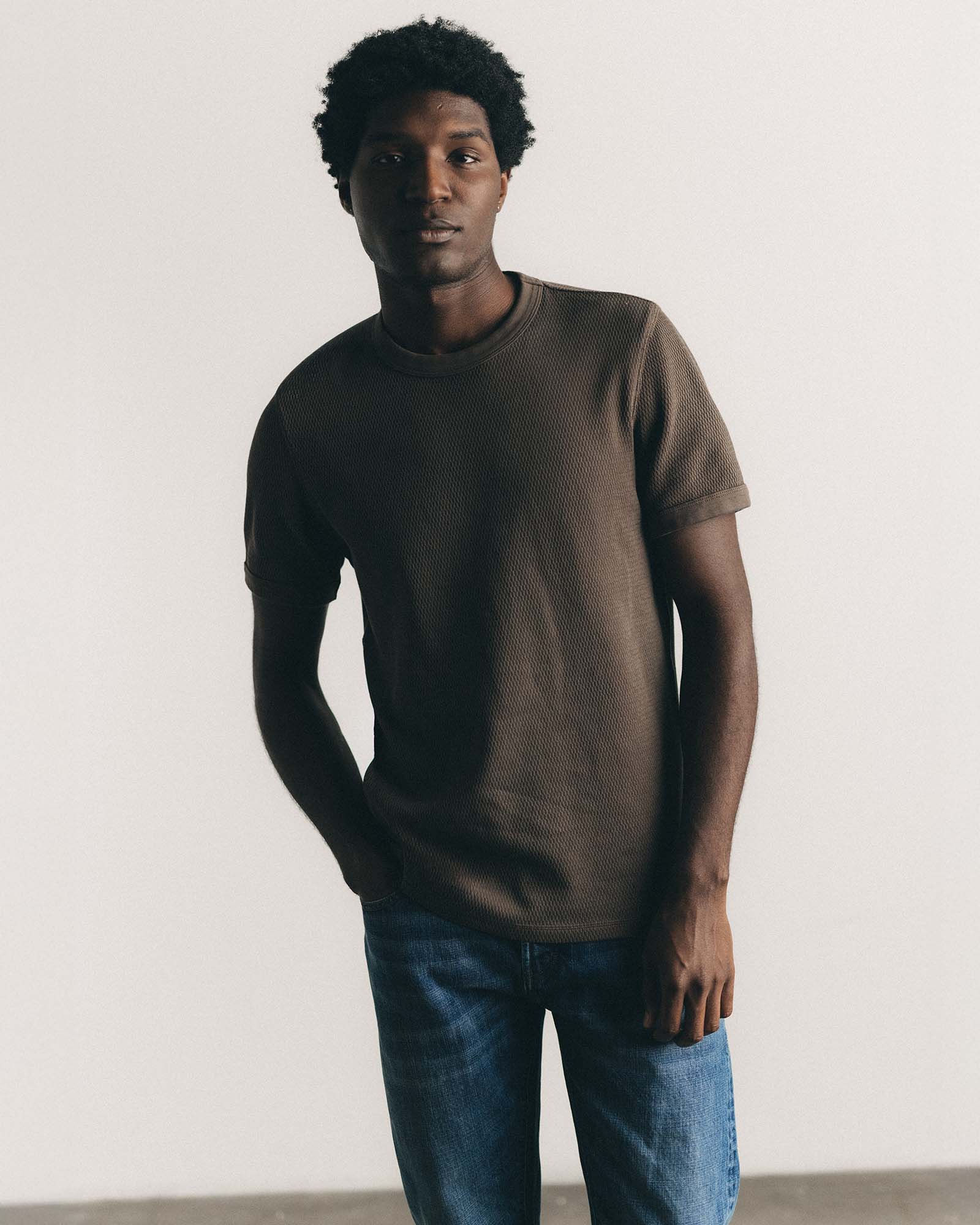 fit model sitting in The Organic Cotton Short Sleeve Crew in Fatigue Olive Waffle, Knits by Taylor Stitch
