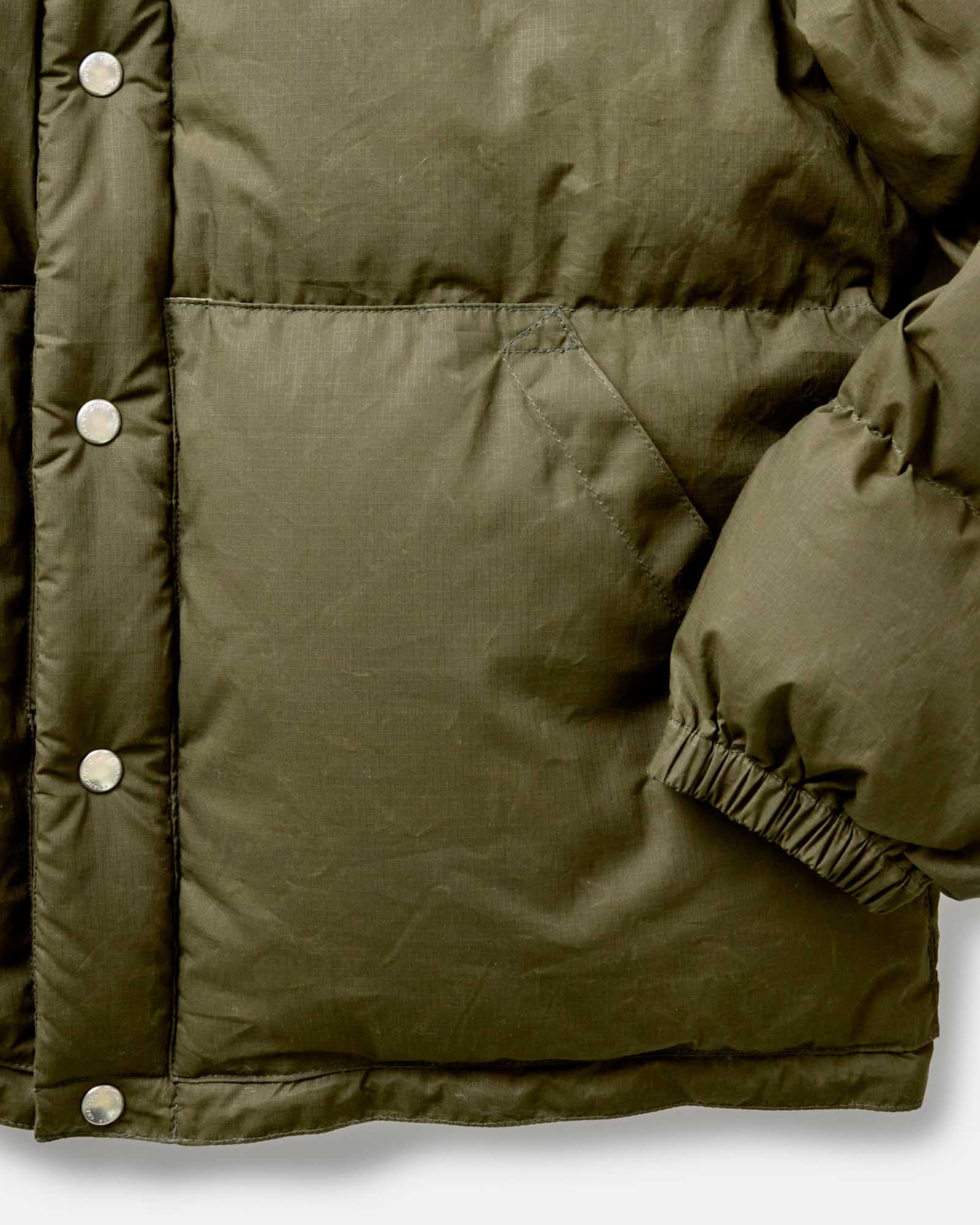 material shot of the cuff on The Down Sweater in Olive Waxed Ripstop, Outerwear by Taylor Stitch