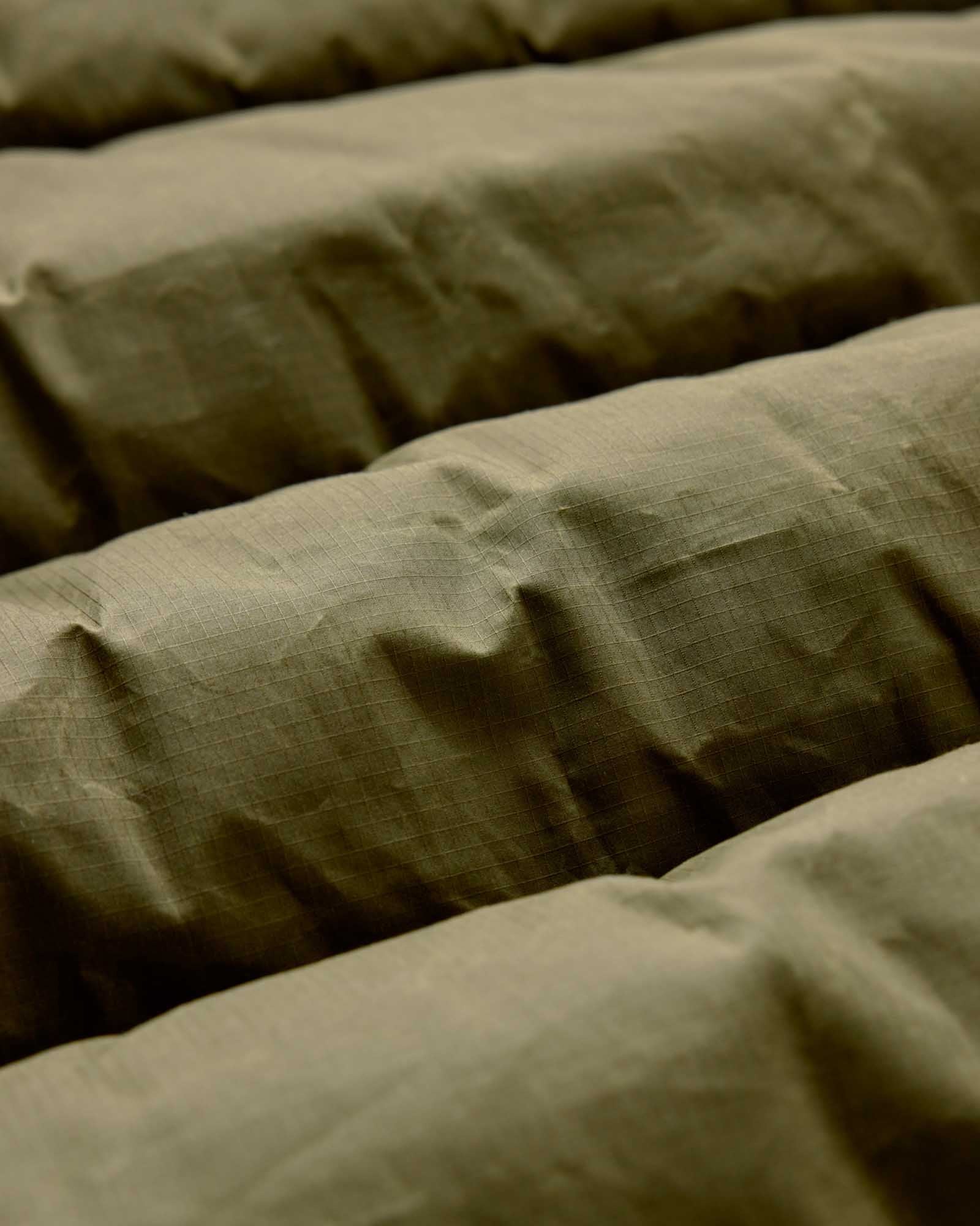 material shot of the fabric on The Down Sweater in Olive Waxed Ripstop, Outerwear by Taylor Stitch