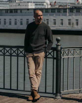 fit model leaning against the wall wearing The Sidecountry Crew in Heather Graphite Merino Waffle