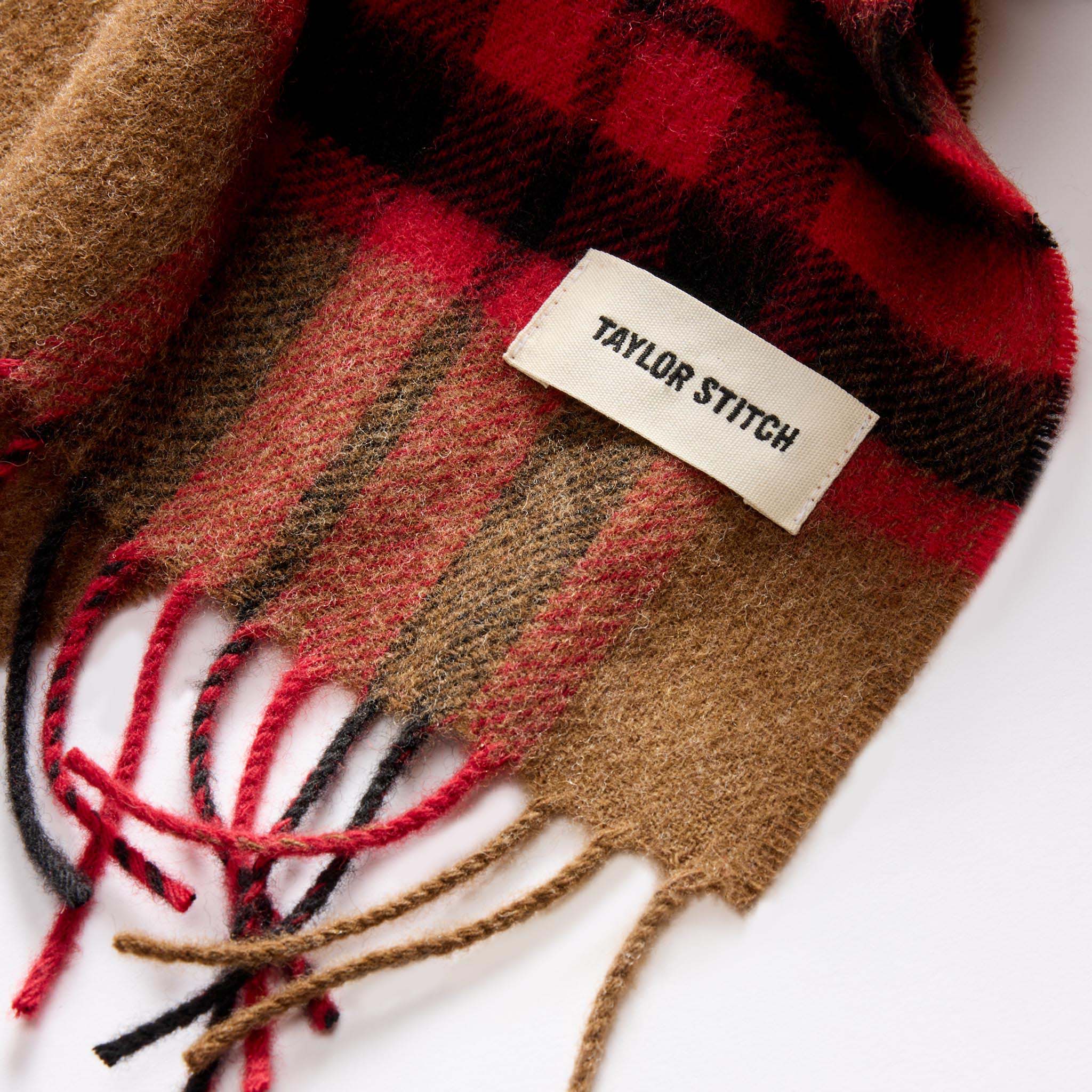 material shot of the TS label on The Fireside Scarf in Camel Tartan Merino, Accessories by Taylor Stitch