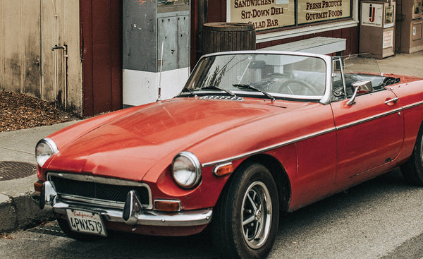 A vintage red open-topped MG car.