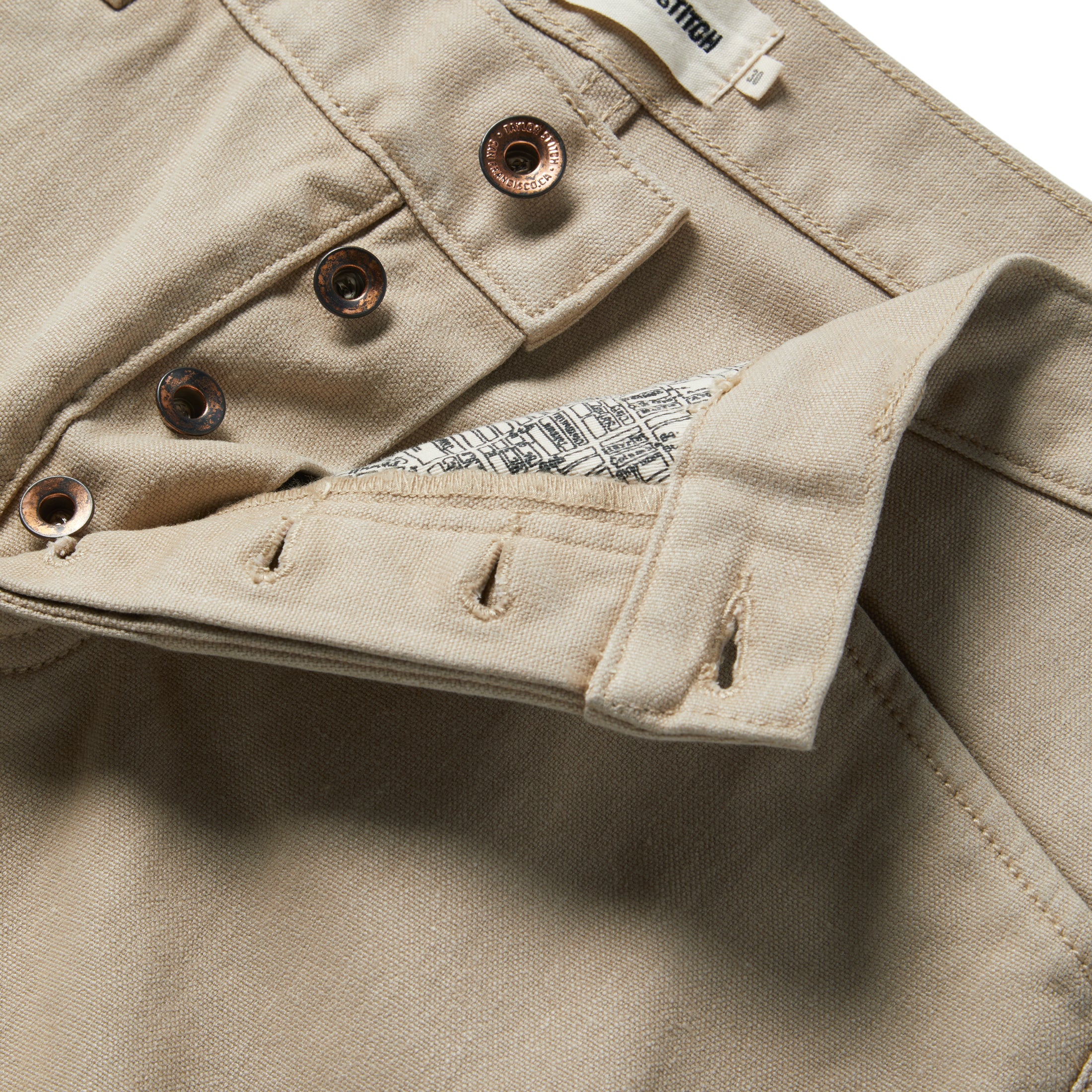material shot of the buttons and map pocket printing on The Camp Pant in Sand Boss Duck, Bottoms by Taylor Stitch