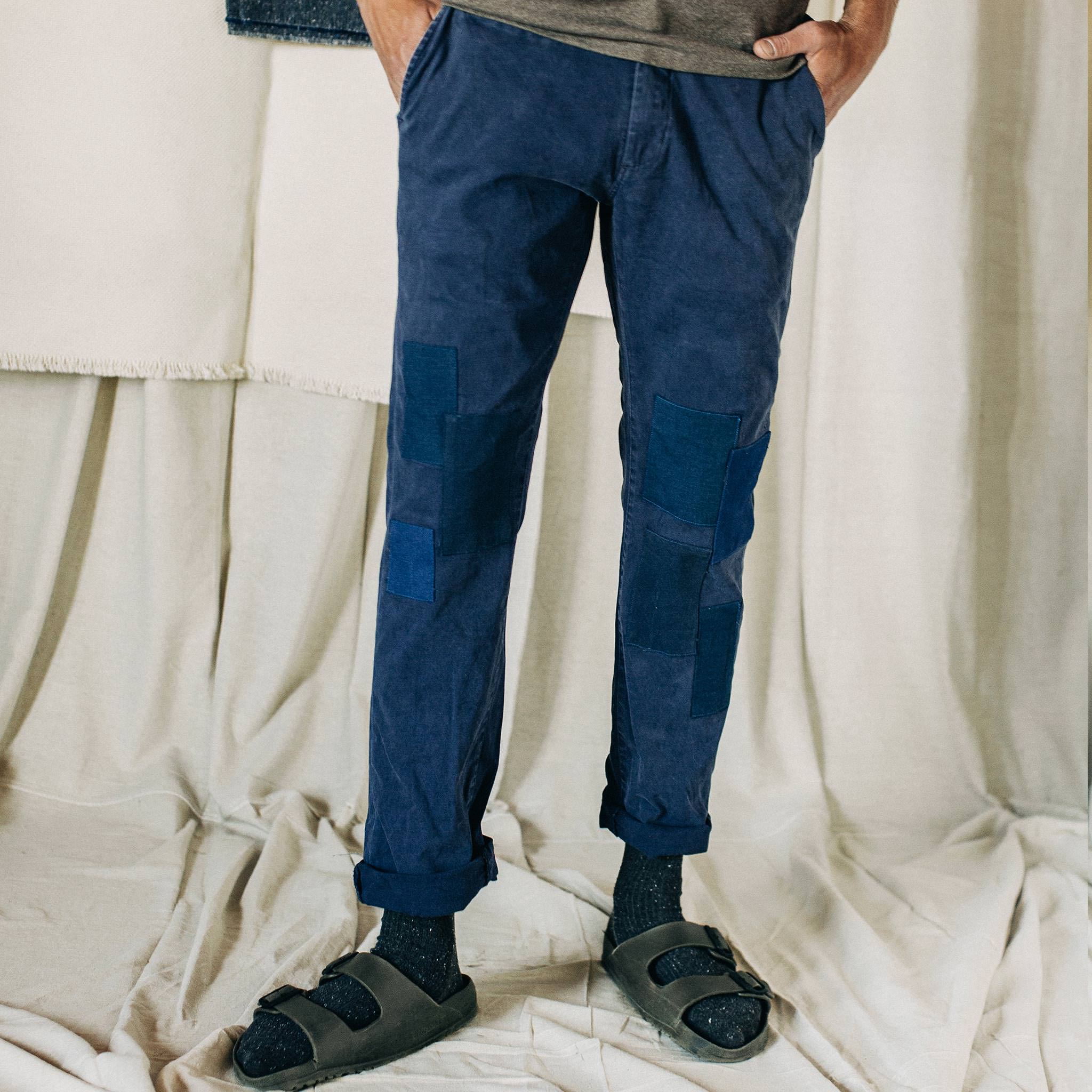 material shot of The Atelier and Repairs Chino in Navy, cuffed on model, in a studio, Bottoms by Taylor Stitch