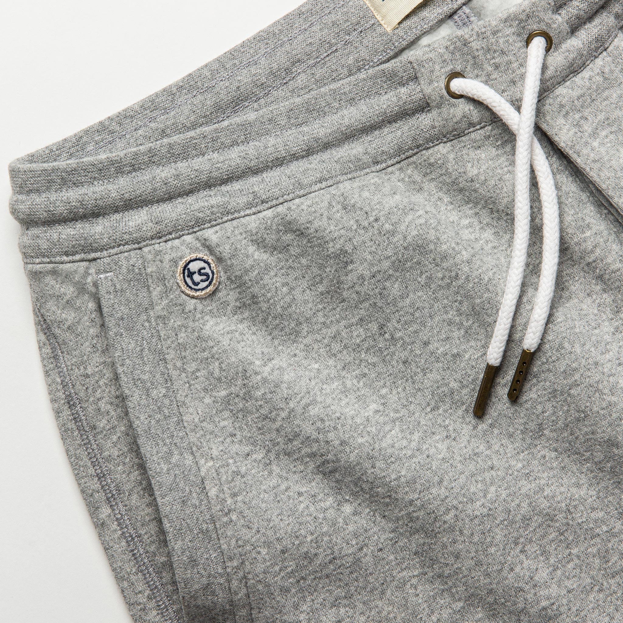 material shot of The Heavy Bag Short in Heather Grey Fleece with left side pocket visible with TS embroidered logo, Pants by Taylor Stitch