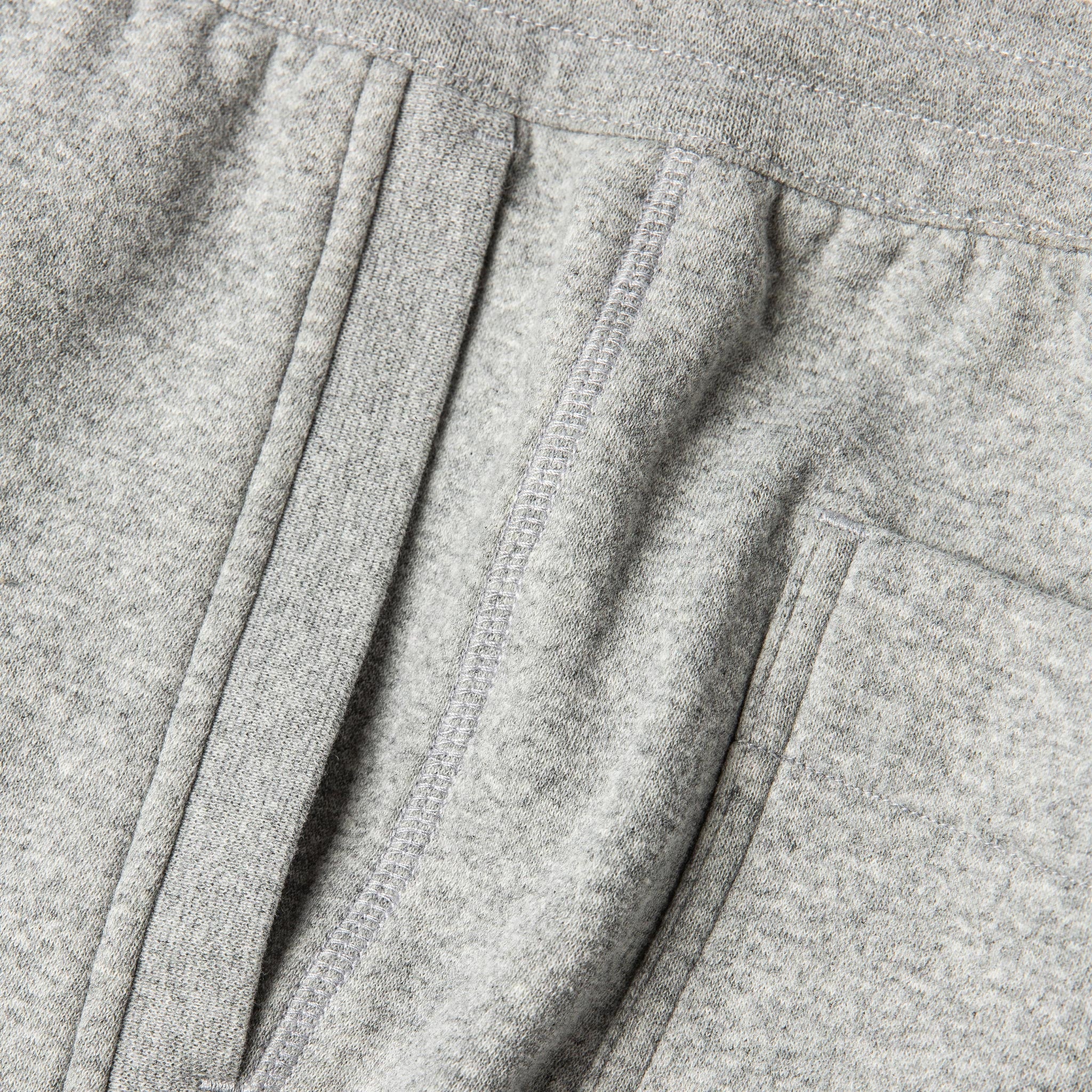 material shot of The Heavy Bag Short in Heather Grey Fleece showing diversity of stitching along the side seam with the ribbing detailing of the diagonal pockets, Pants by Taylor Stitch