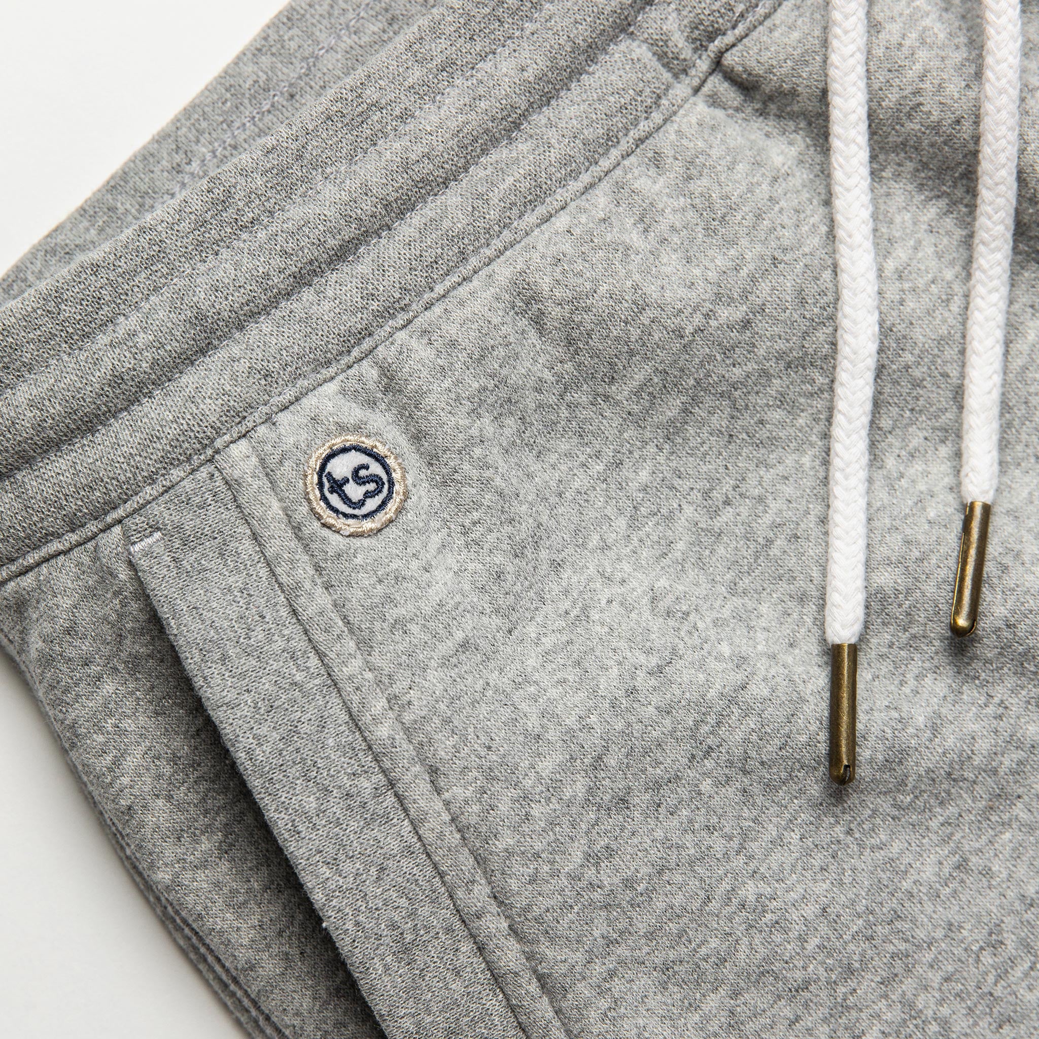 material shot of The Heavy Bag Short in Heather Grey Fleece with TS embroidered logo visible above right side hand pocket, Pants by Taylor Stitch