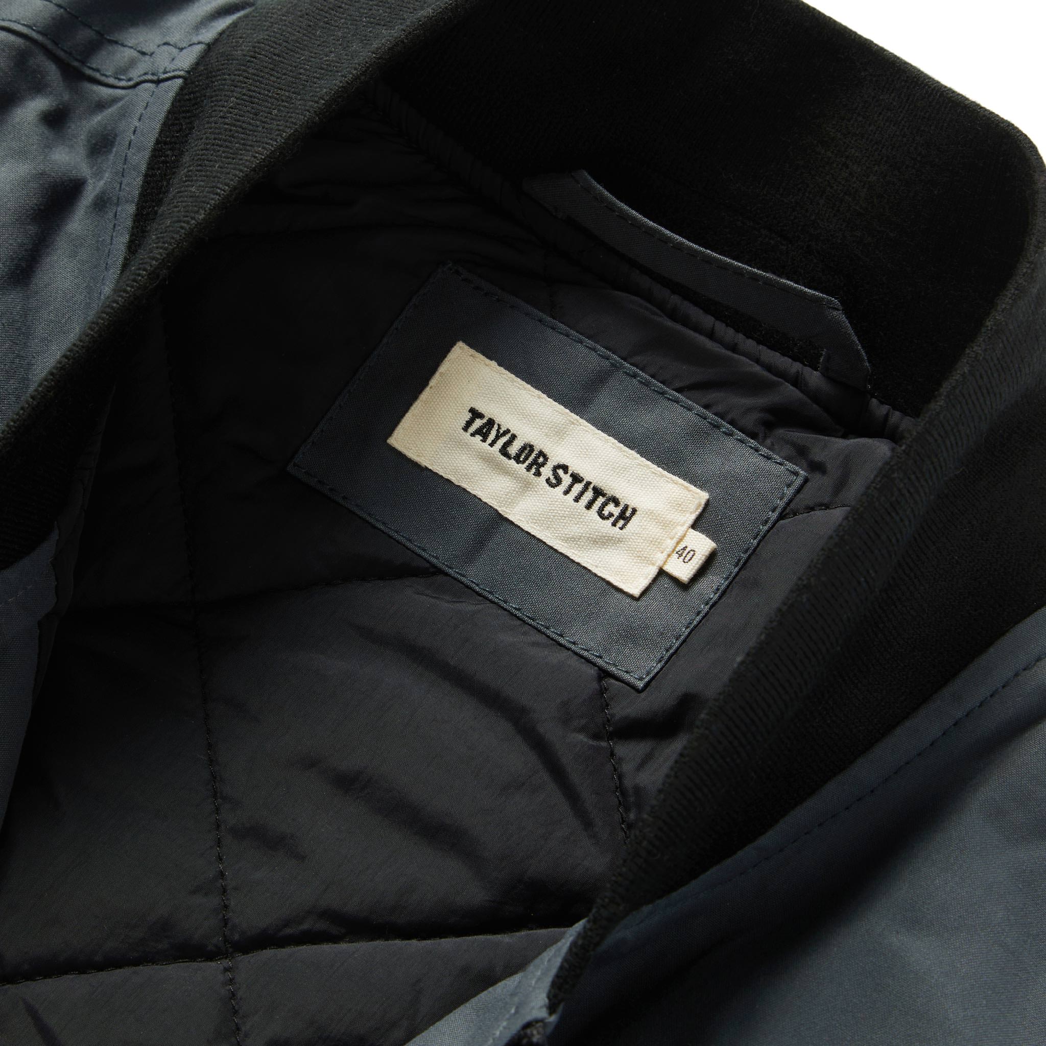 material shot showing interior label of The Anchorage Vest in Charcoal Dry Wax, Outerwear by Taylor Stitch