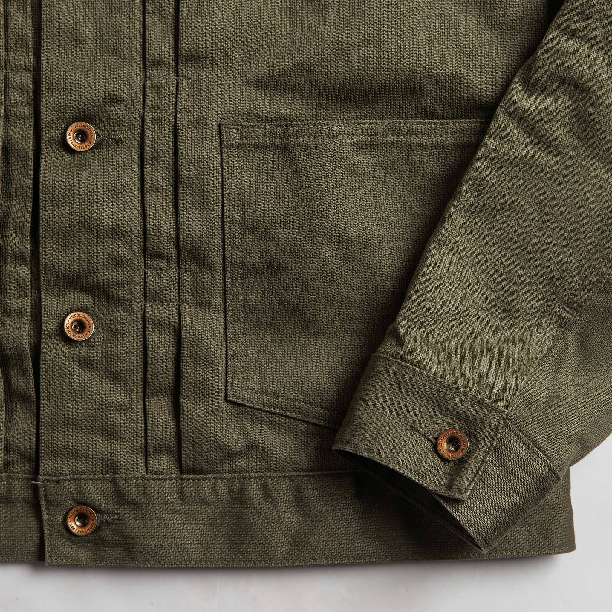 material shot of The Ryder Jacket in Yoshiwa Mills Olive showing front waist pocket and sleeve cuff, Outerwear by Taylor Stitch
